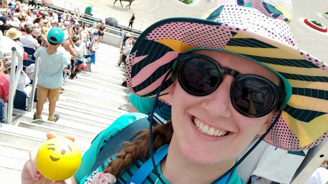 Amandine, a volunteer at the Paris 2024 Olympic Games, posing with her equipment while holding a foam ball in Advans Group colors.